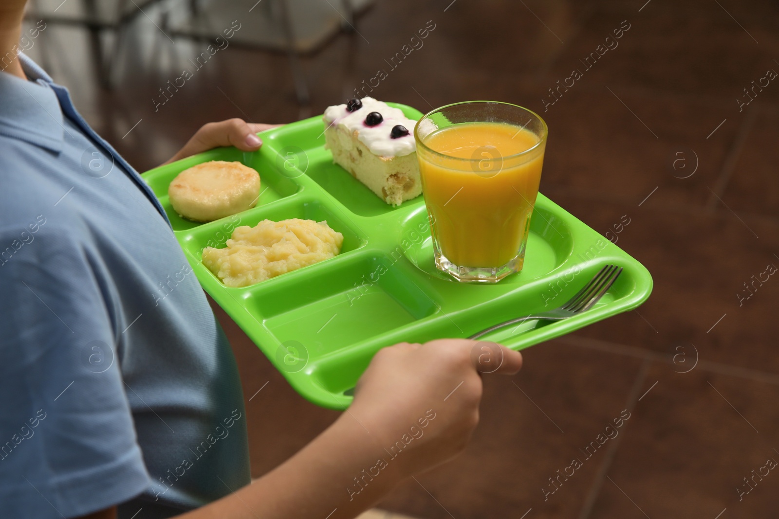 Photo of Boy holding tray with healthy food in school canteen, closeup