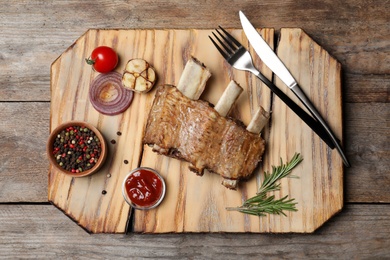 Flat lay composition with roasted ribs on wooden background. Tasty meat