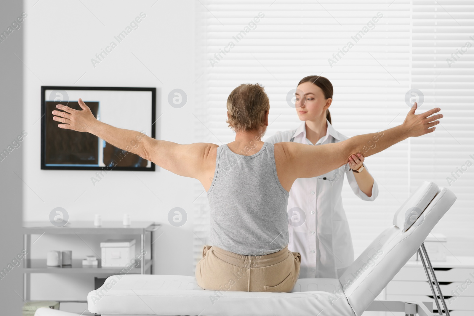 Photo of Professional female orthopedist examining patient in clinic