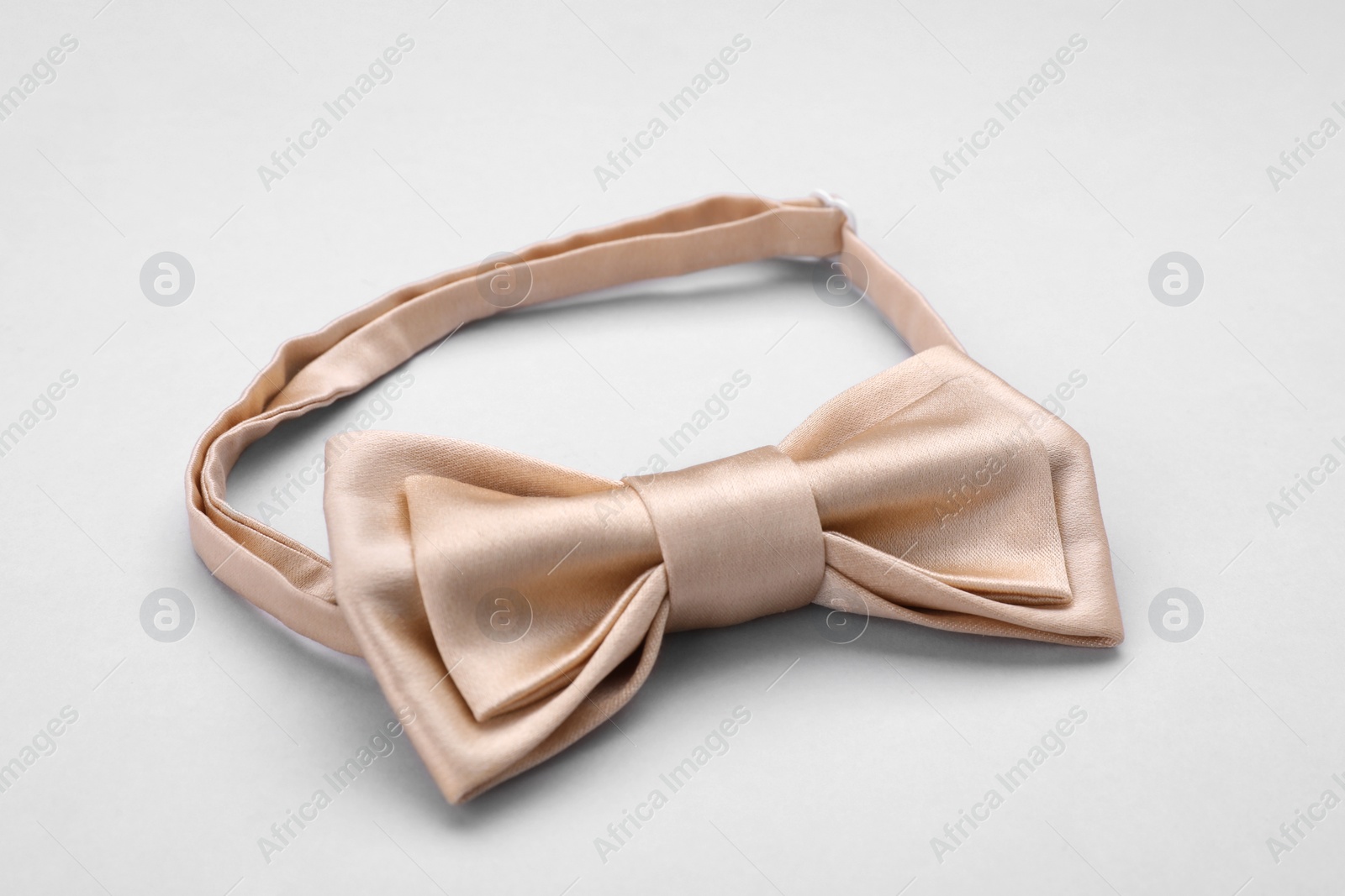 Photo of Stylish beige bow tie on white background