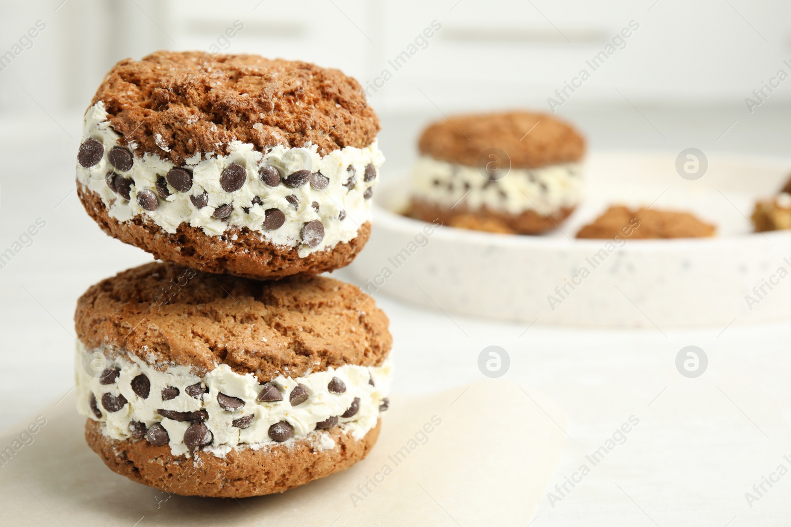 Photo of Sweet delicious ice cream cookie sandwiches with chocolate chips on table, space for text