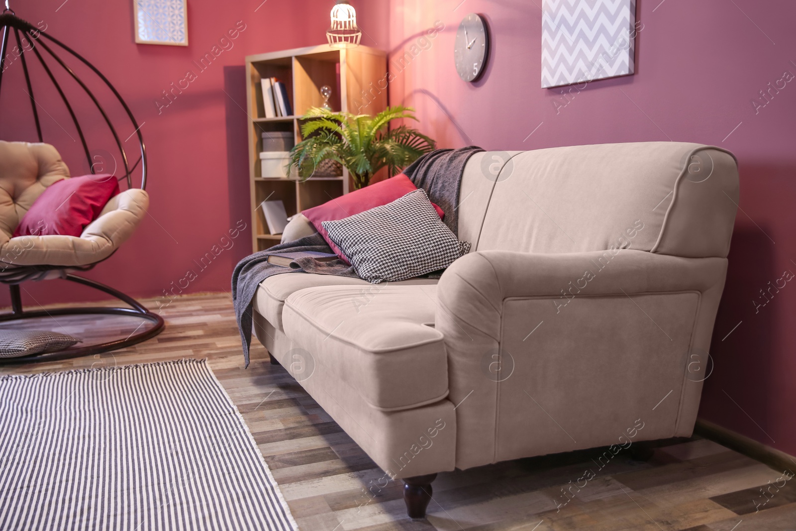 Photo of Elegant living room interior with comfortable sofa and swing chair