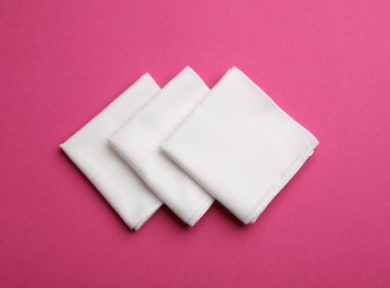 Photo of Stylish white handkerchiefs on pink background, flat lay