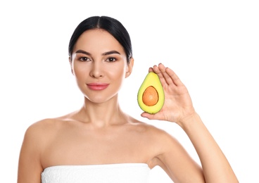 Young woman with silky skin after face mask holding avocado on white background