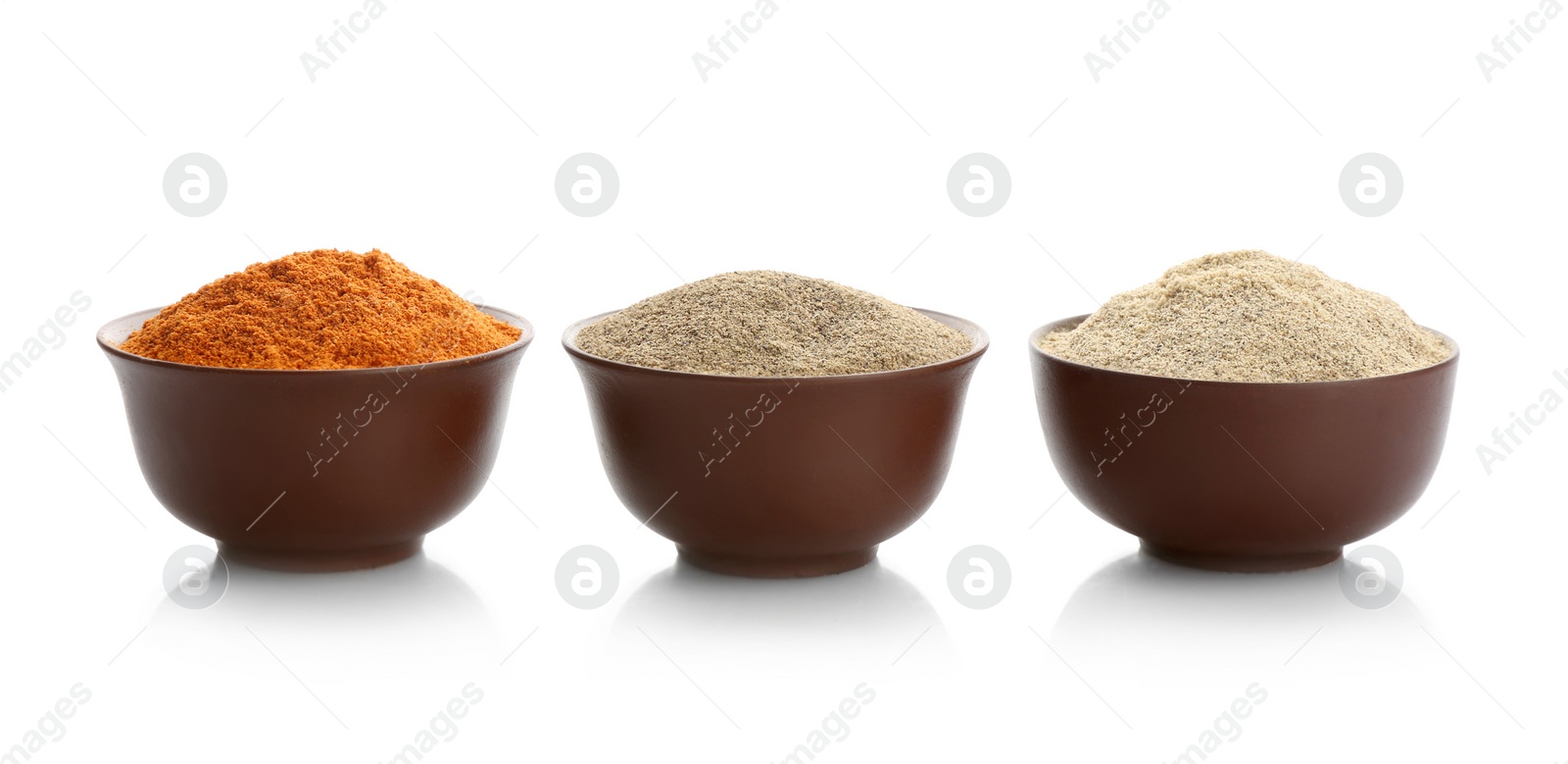 Photo of Bowls with different kinds of milled pepper on white background