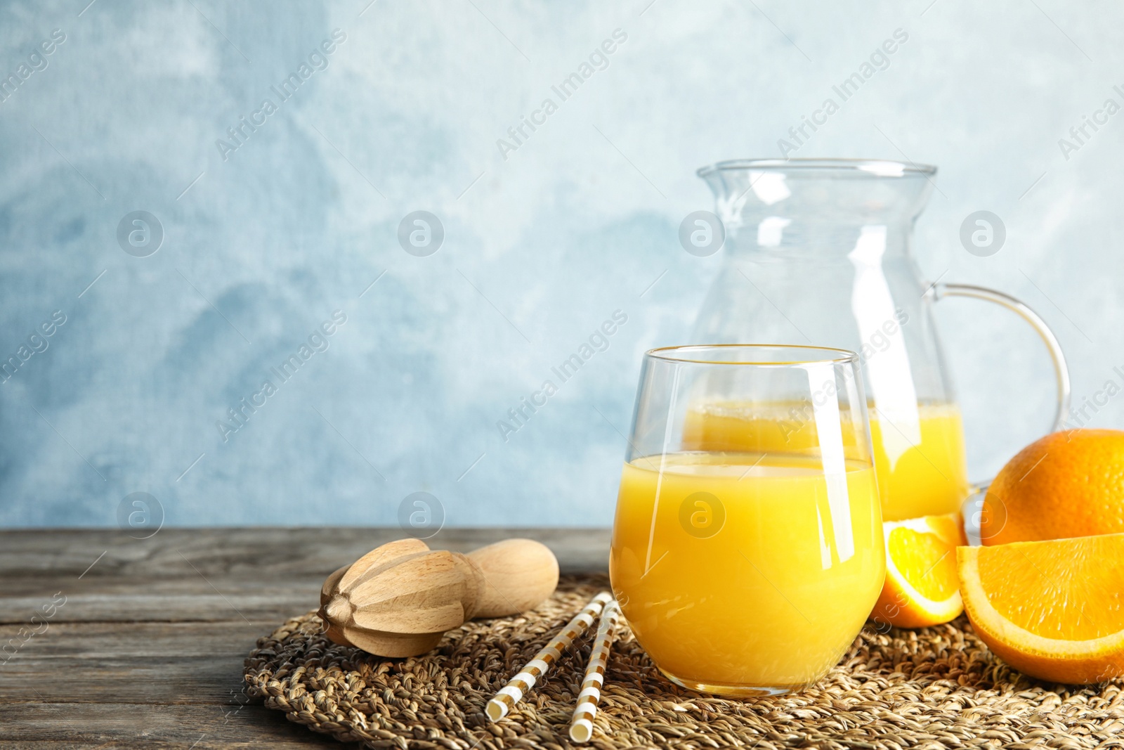 Photo of Composition with orange juice and fresh fruit on table, space for text