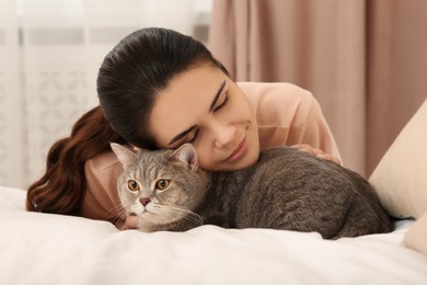 Photo of Young woman with adorable cat at home