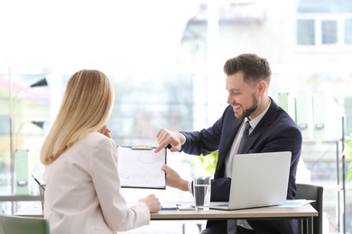 Photo of Young consultant working with client in office