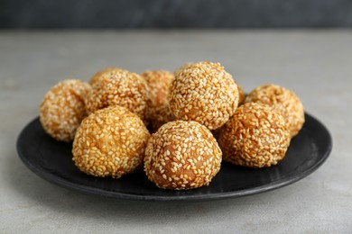 Photo of Delicious sesame balls on light grey table, closeup