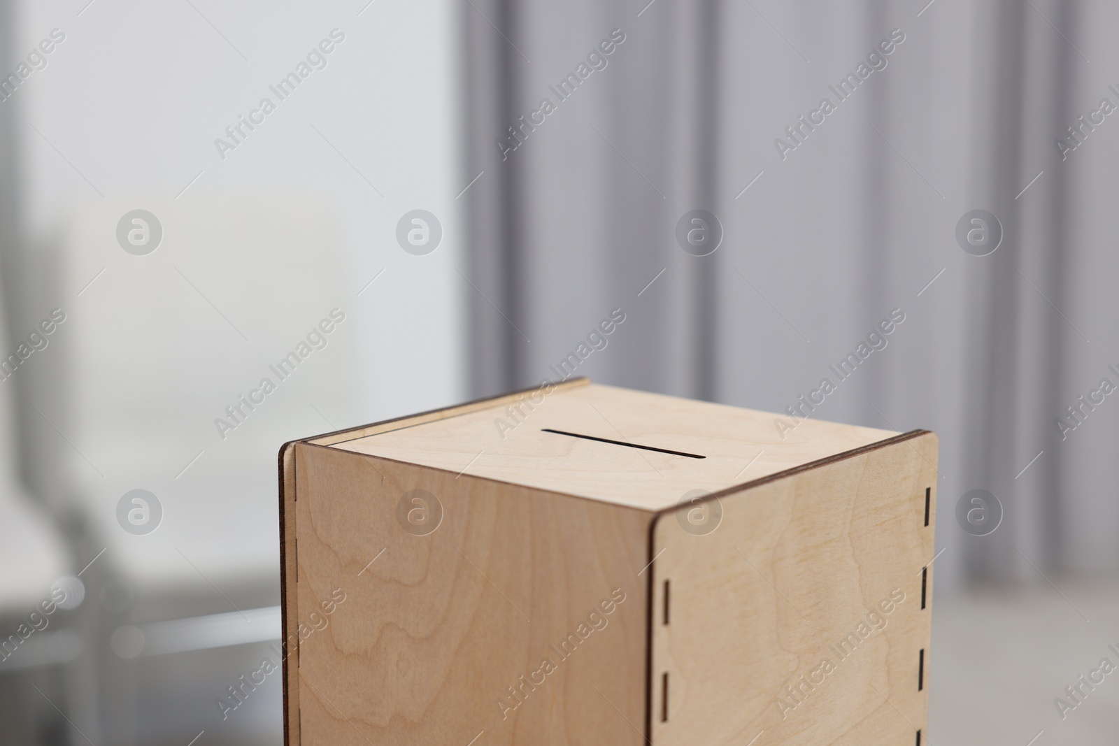 Photo of Wooden ballot box on blurred background, closeup. Space for text