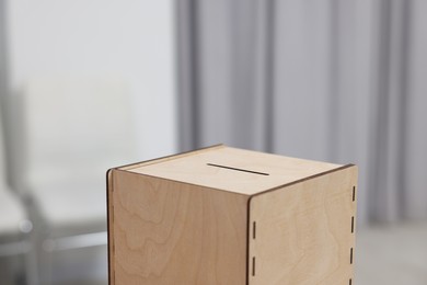 Photo of Wooden ballot box on blurred background, closeup. Space for text