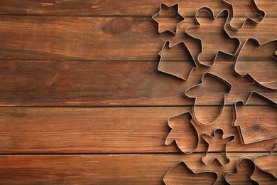 Photo of Cookie cutters on wooden table, flat lay. Space for text