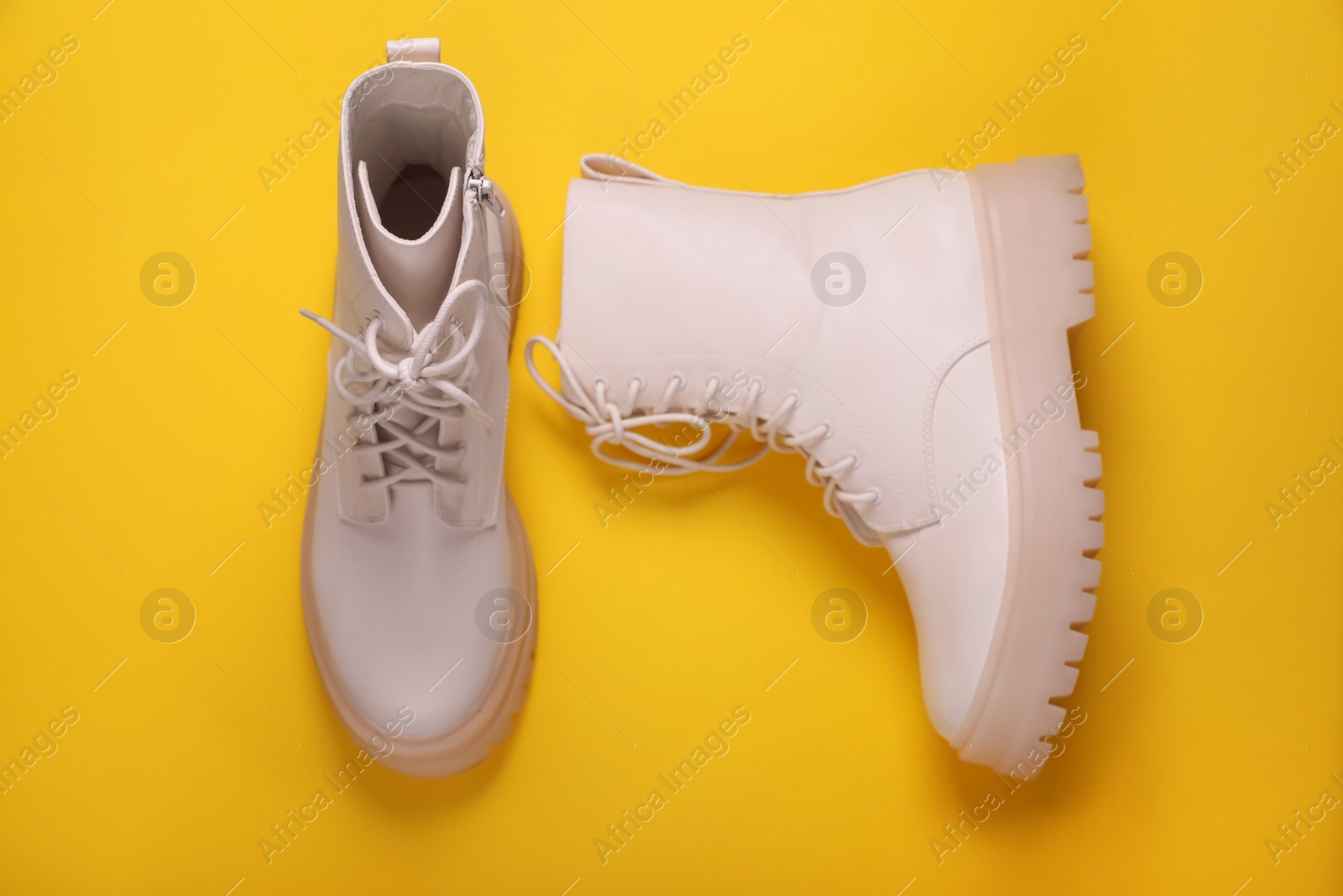 Photo of Pair of stylish shoes on yellow background, flat lay