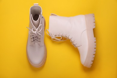 Pair of stylish shoes on yellow background, flat lay