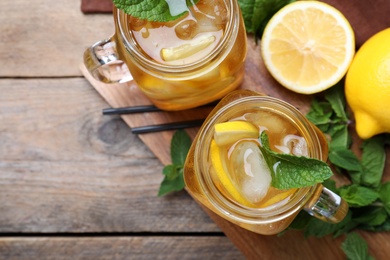 Photo of Delicious iced tea on wooden table, flat lay. Space for text