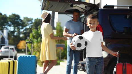 Photo of Happy family unloading car near house outdoors. Moving day