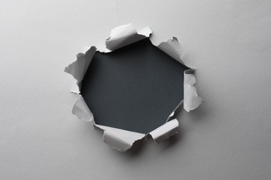 Photo of Hole in white paper on black background