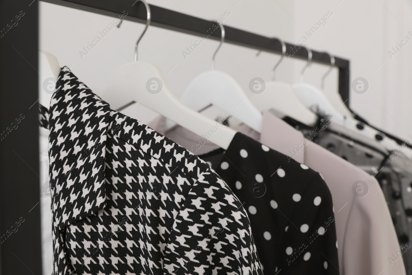 Photo of Rack with stylish clothes in dressing room