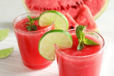 Photo of Tasty summer watermelon drink with lime and mint on table, closeup