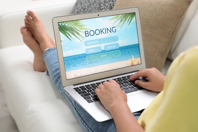 Photo of Woman booking tickets online indoors, closeup. Travel agency concept