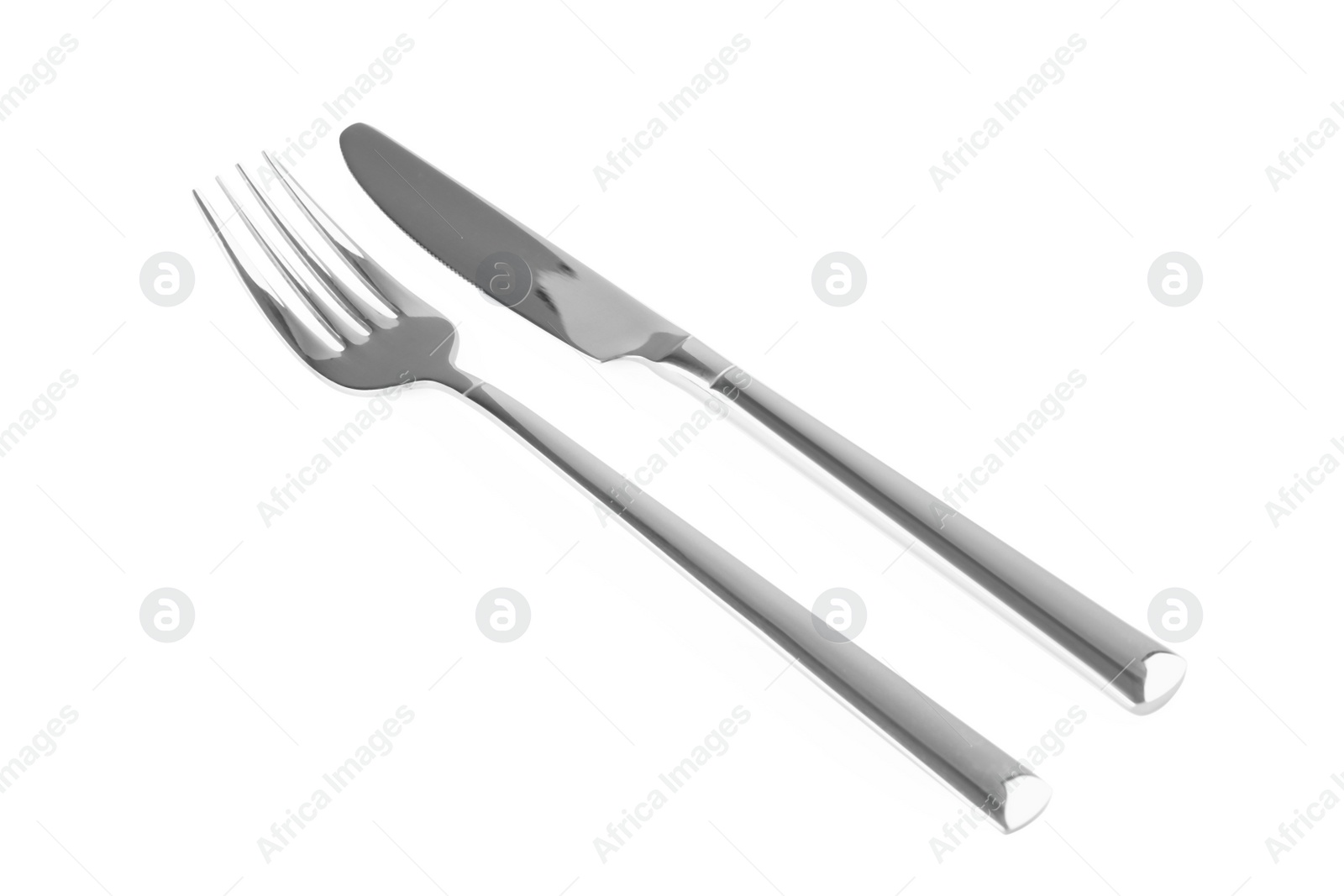 Photo of New shiny fork and knife on white background