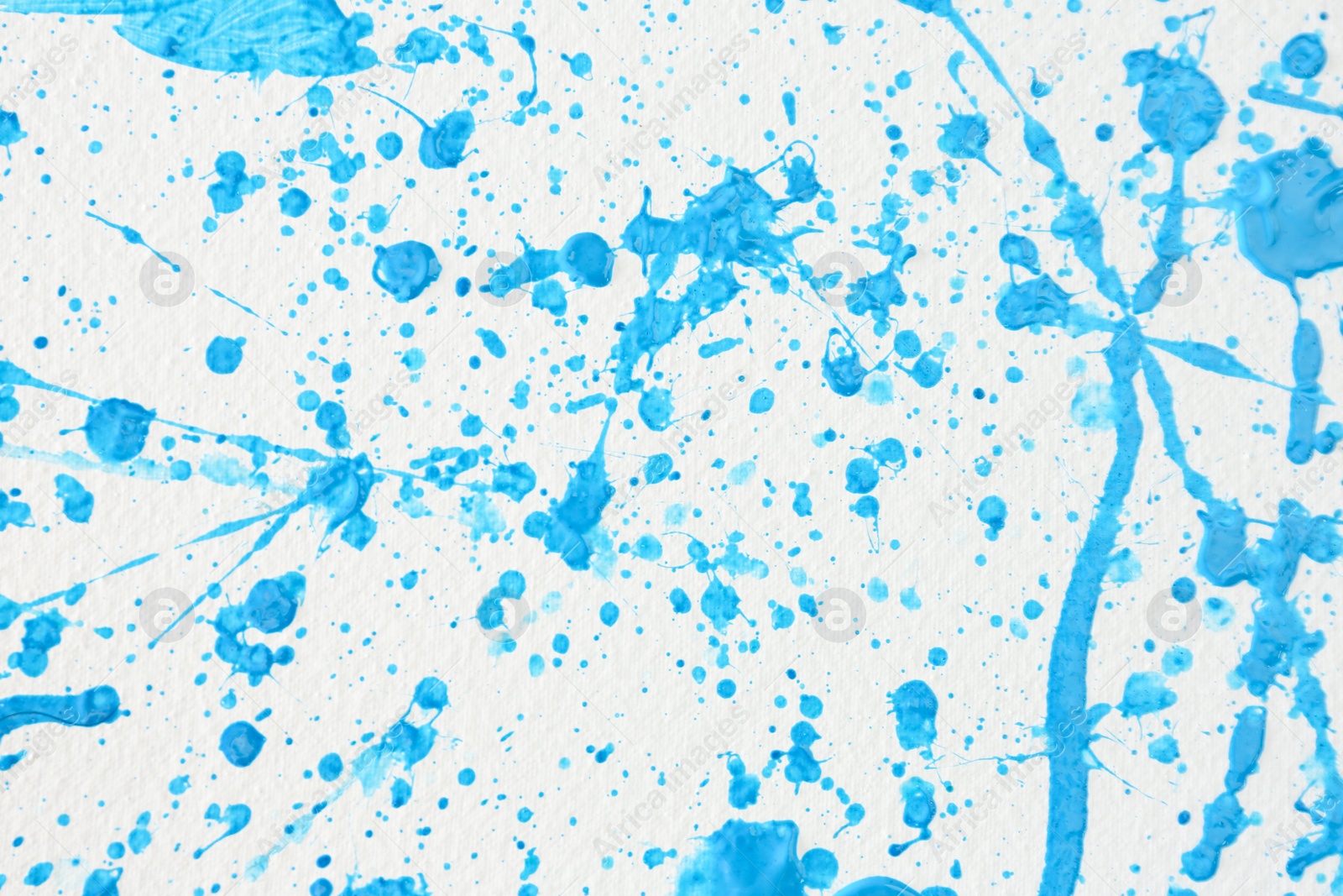 Photo of Blue paint splashes on white canvas as background. Art and creativity