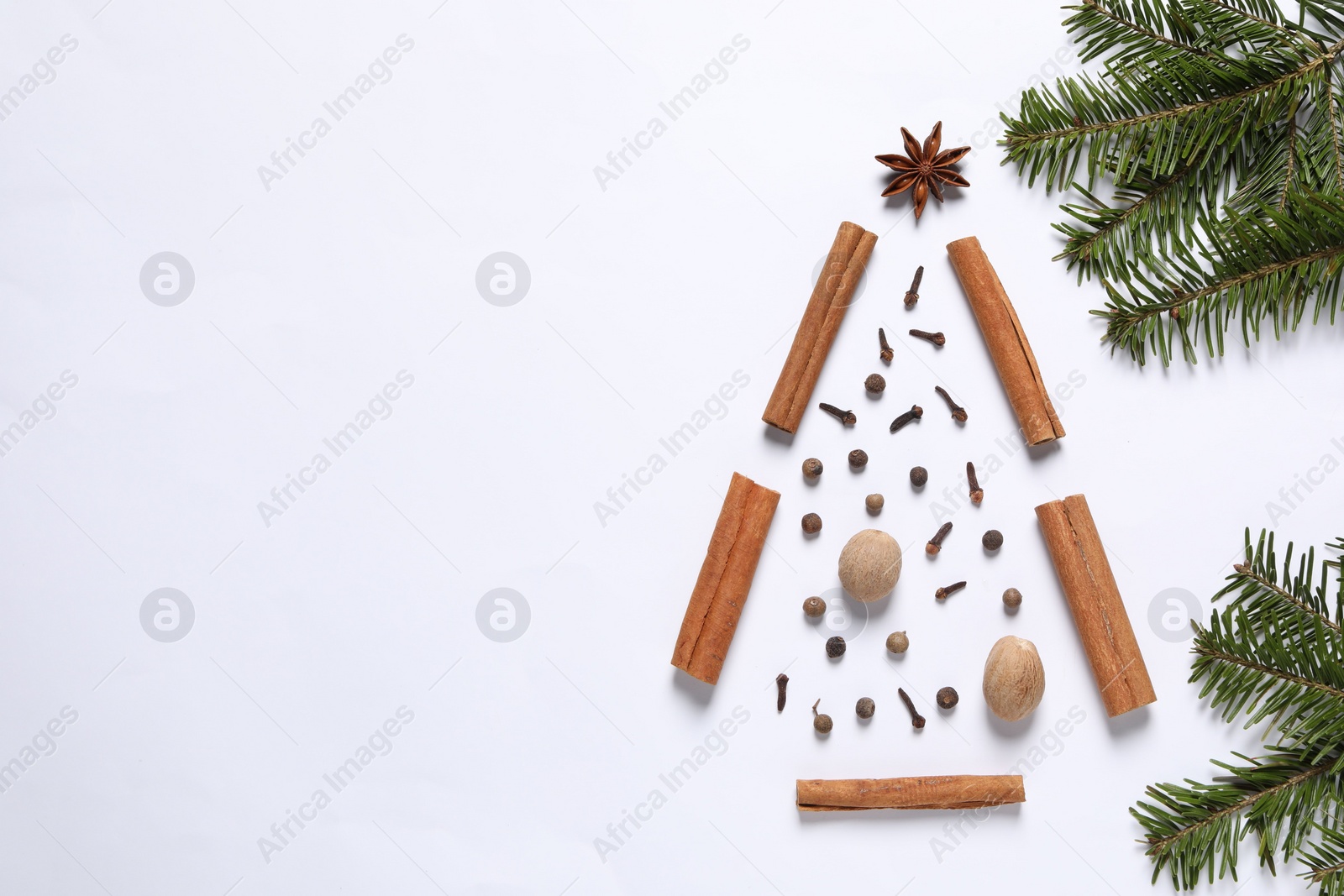 Photo of Christmas tree made of different spices and fir branches on white table, flat lay. Space for text