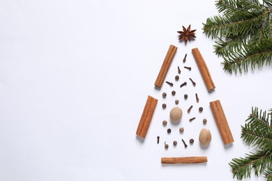 Photo of Christmas tree made of different spices and fir branches on white table, flat lay. Space for text