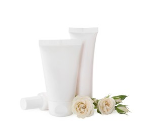Tubes of hand cream and roses on white background