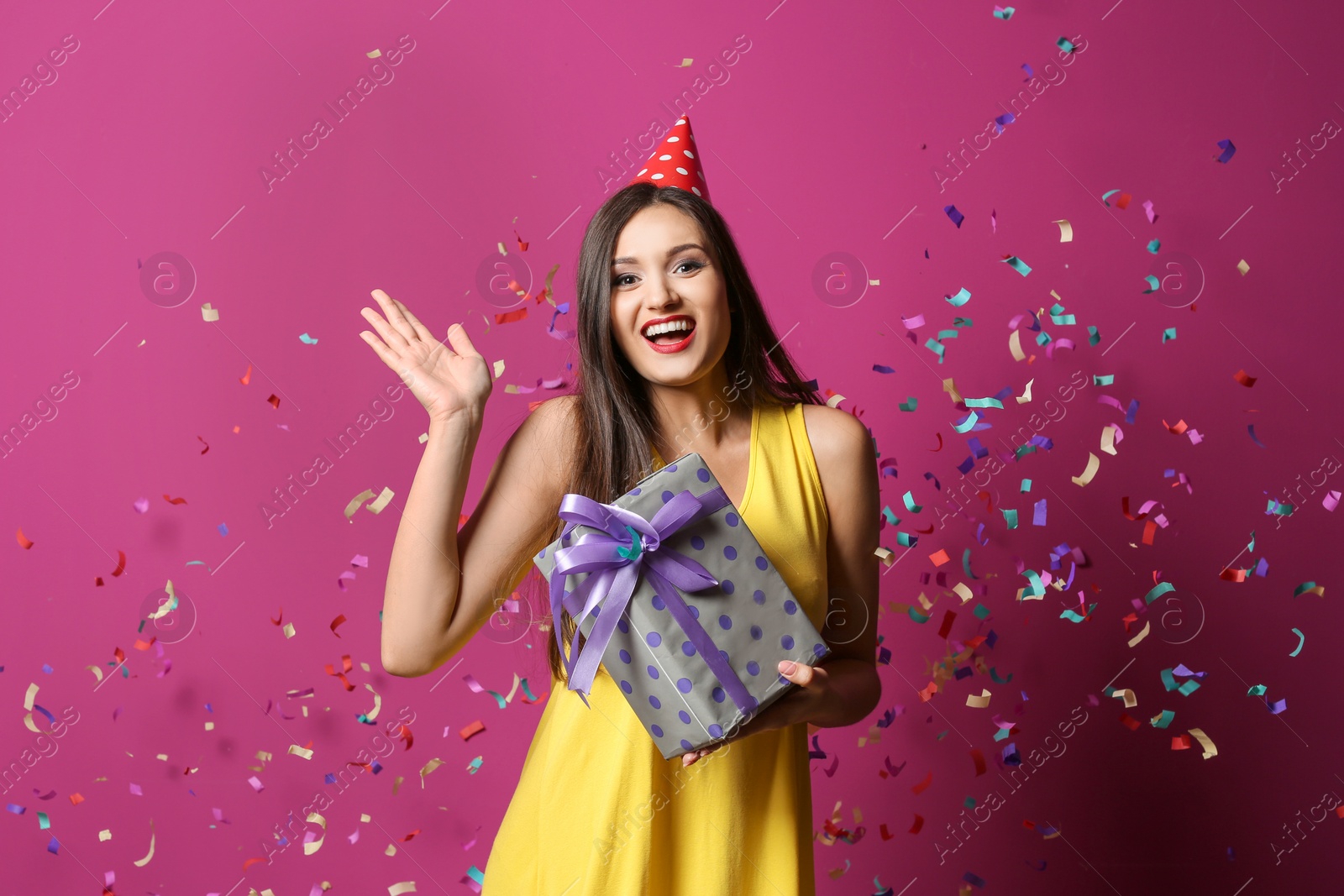 Photo of Young woman with birthday gift on color background