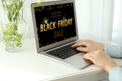 Image of Black Friday. Woman shopping online using laptop at table, closeup