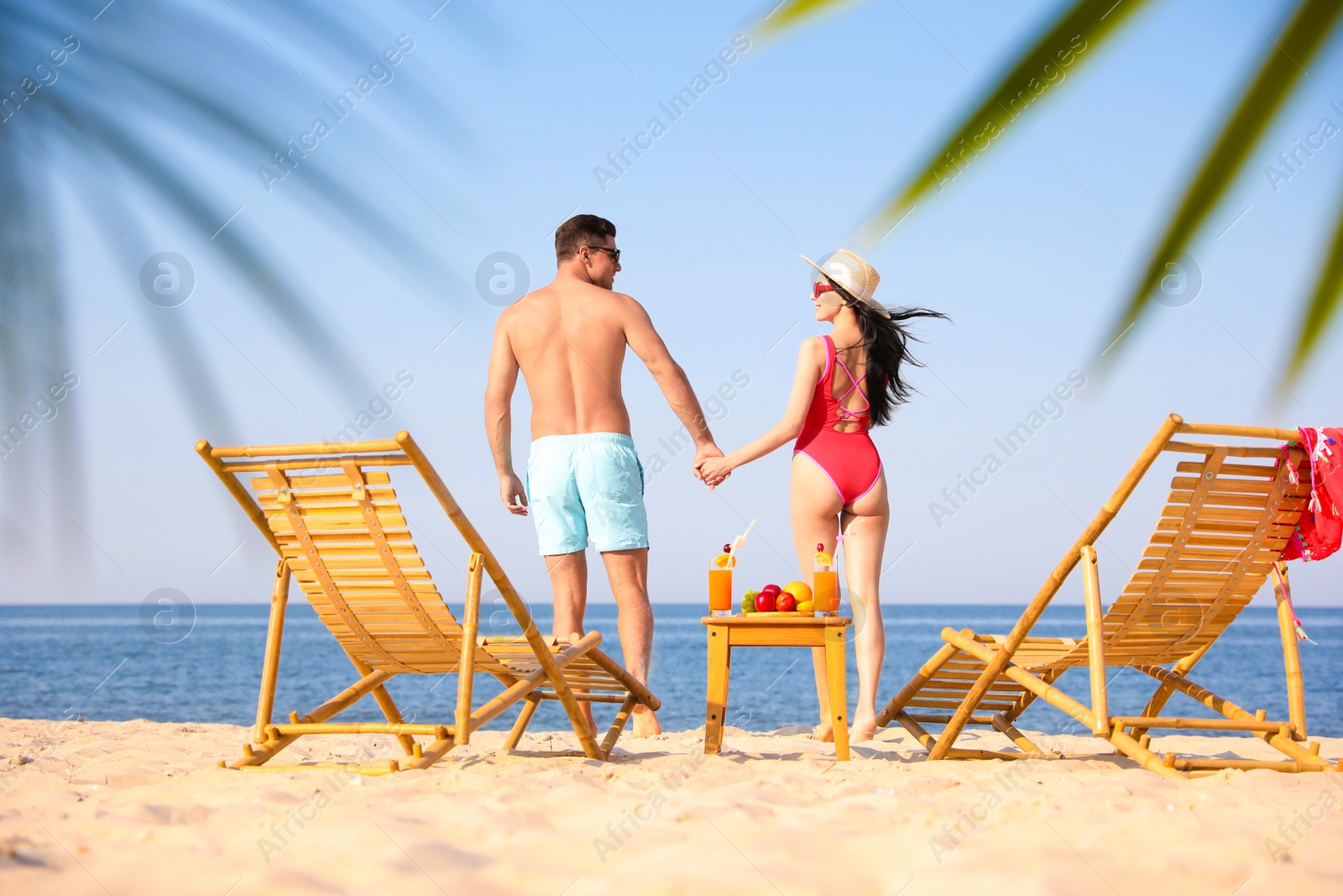 Photo of Happy couple resting on sunny beach at resort