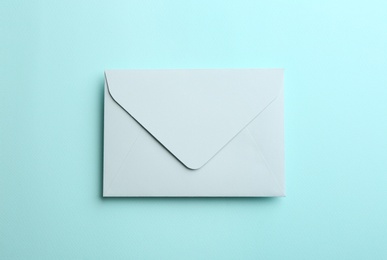 Paper envelope on light blue background, top view