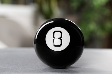 Magic eight ball on light gray table, closeup