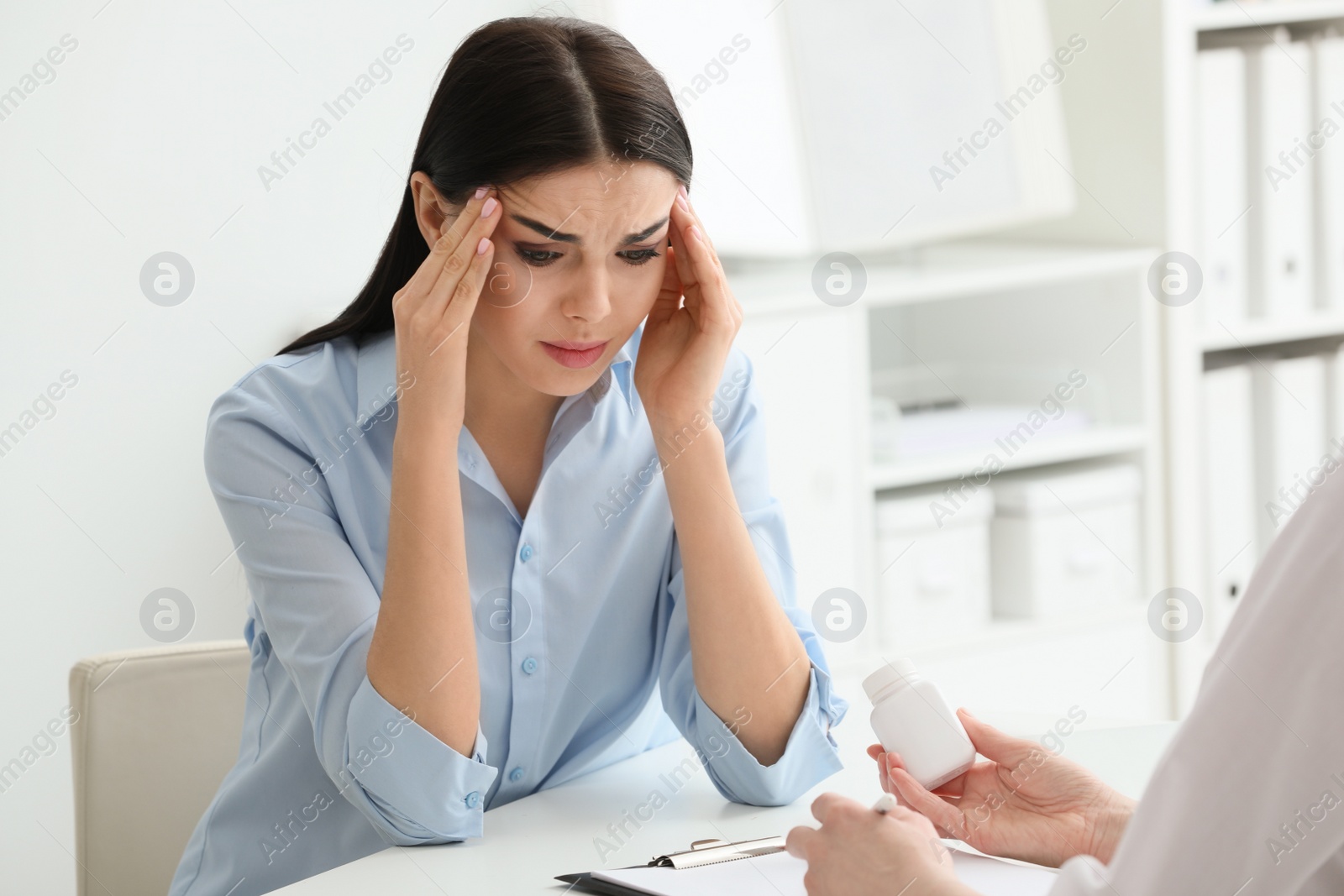 Photo of Young woman suffering from migraine in hospital