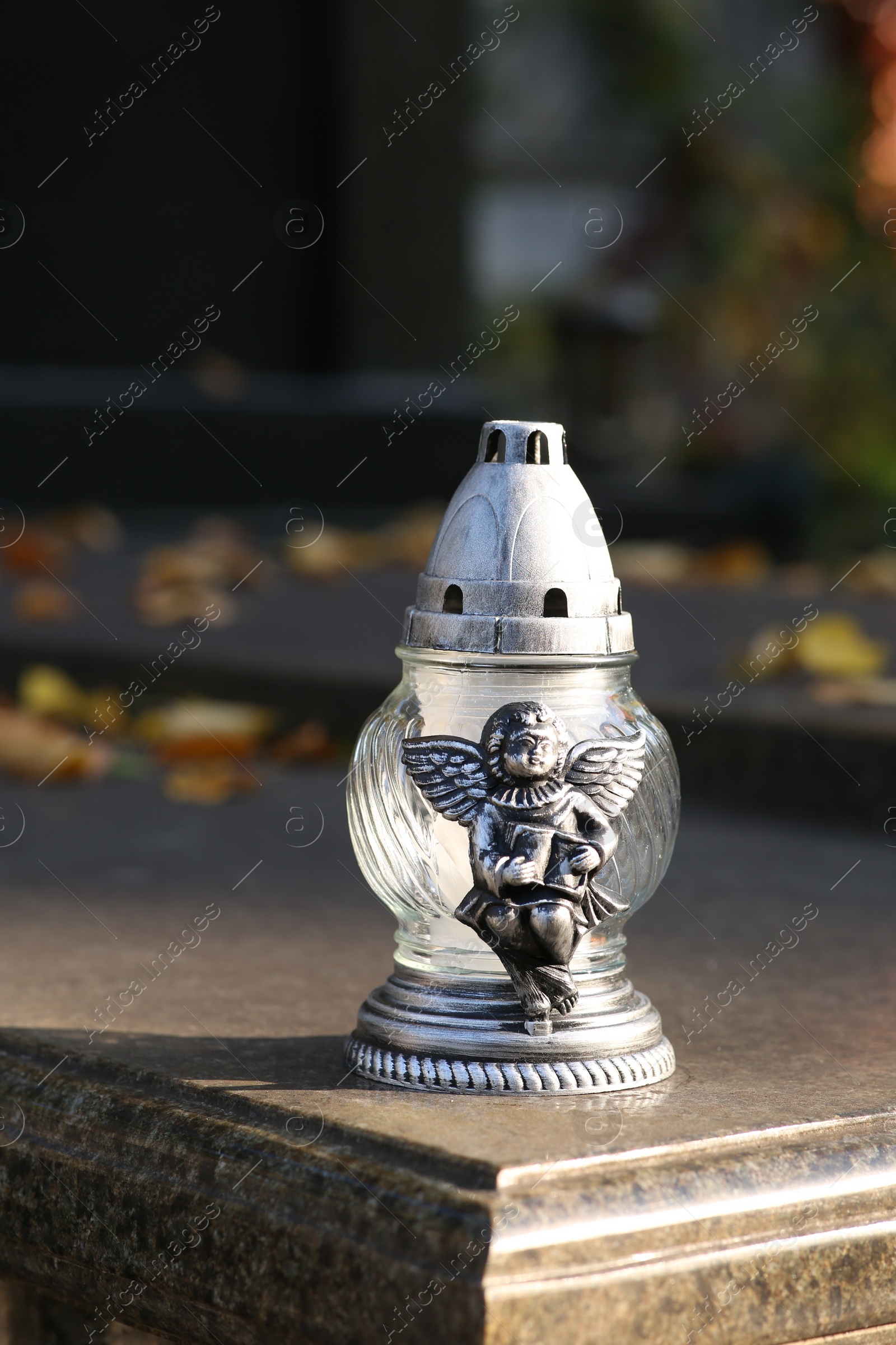 Photo of Grave lantern on granite surface in cemetery