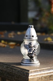 Grave lantern on granite surface in cemetery