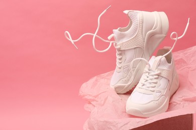 Photo of Stylish presentationtrendy sneakers on pink background. Space for text