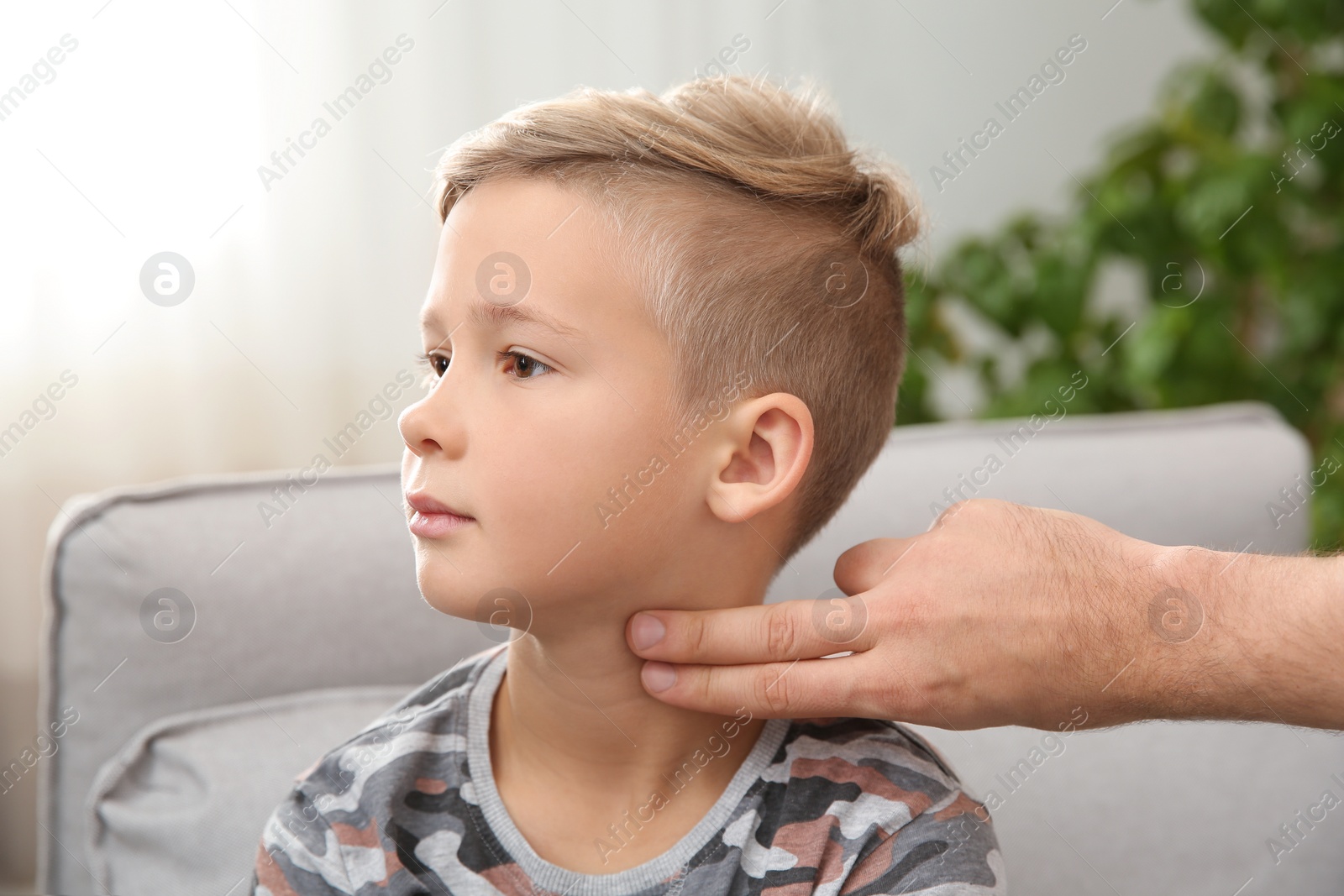 Photo of Man checking little boy's pulse with fingers indoors