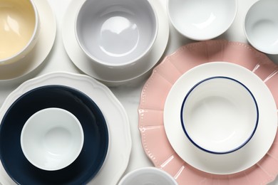 Beautiful ceramic dishware on white table, flat lay