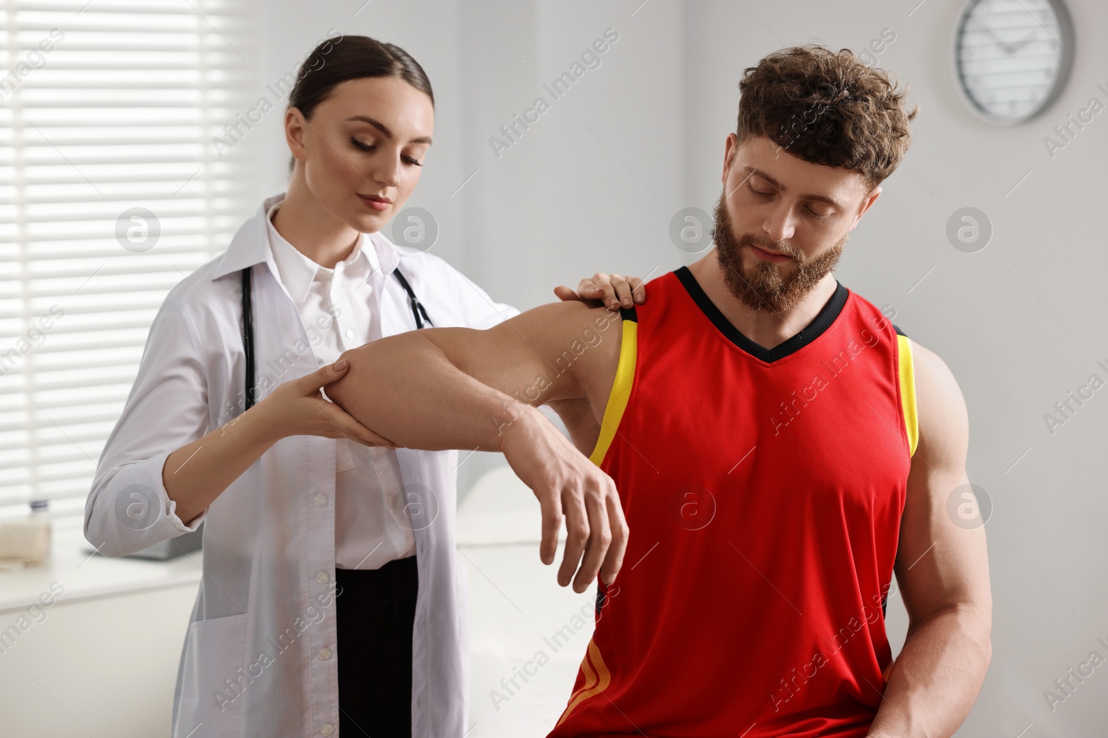 Photo of Sports injury. Doctor examining patient's hand in hospital