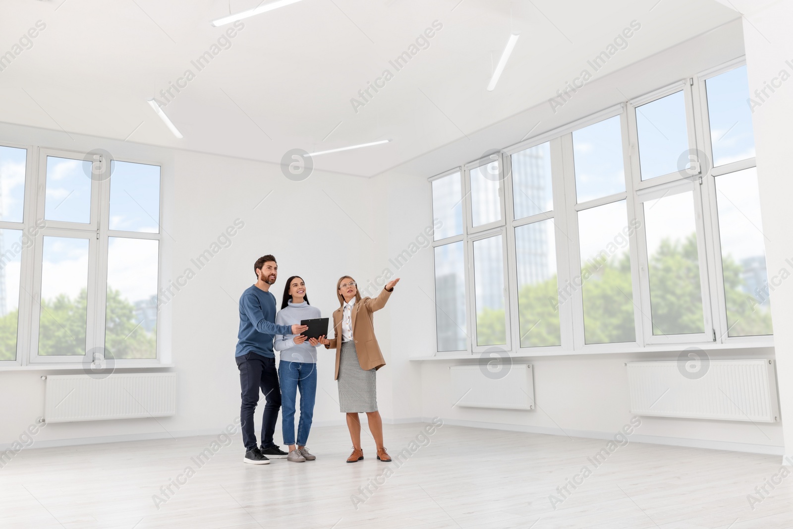 Photo of Real estate agent showing new apartment to couple