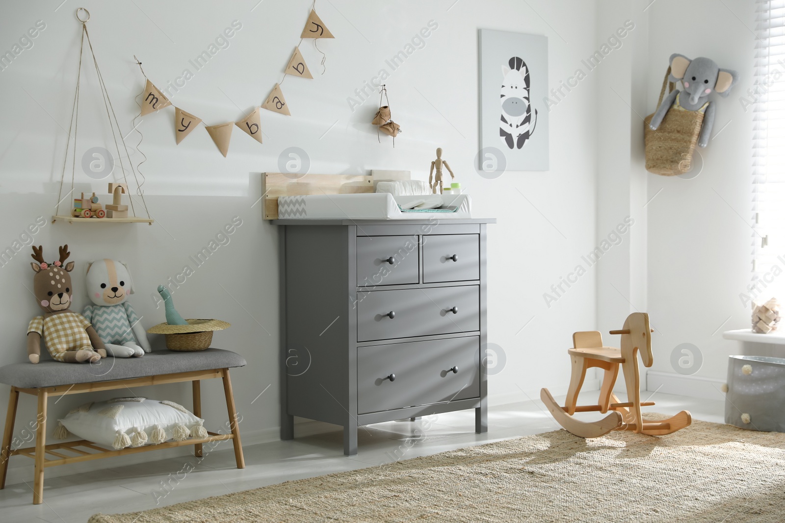 Photo of Beautiful baby room interior with toys and modern changing table