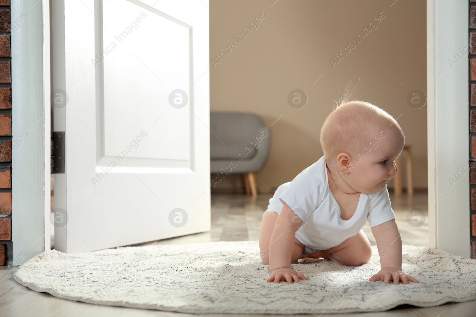 Photo of Cute little baby crawling on rug indoors, space for text