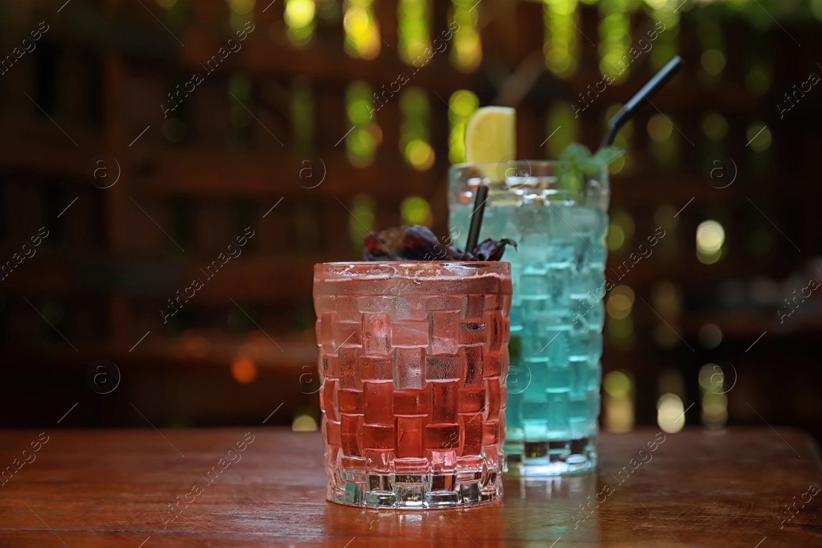 Photo of Glasses with delicious cocktails on counter in bar