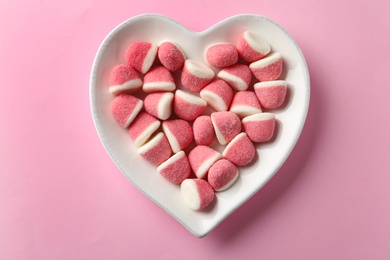 Photo of Plate of sweet jelly candies on pink background, top view
