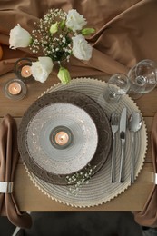 Festive table setting with beautiful candles and floral decor, flat lay