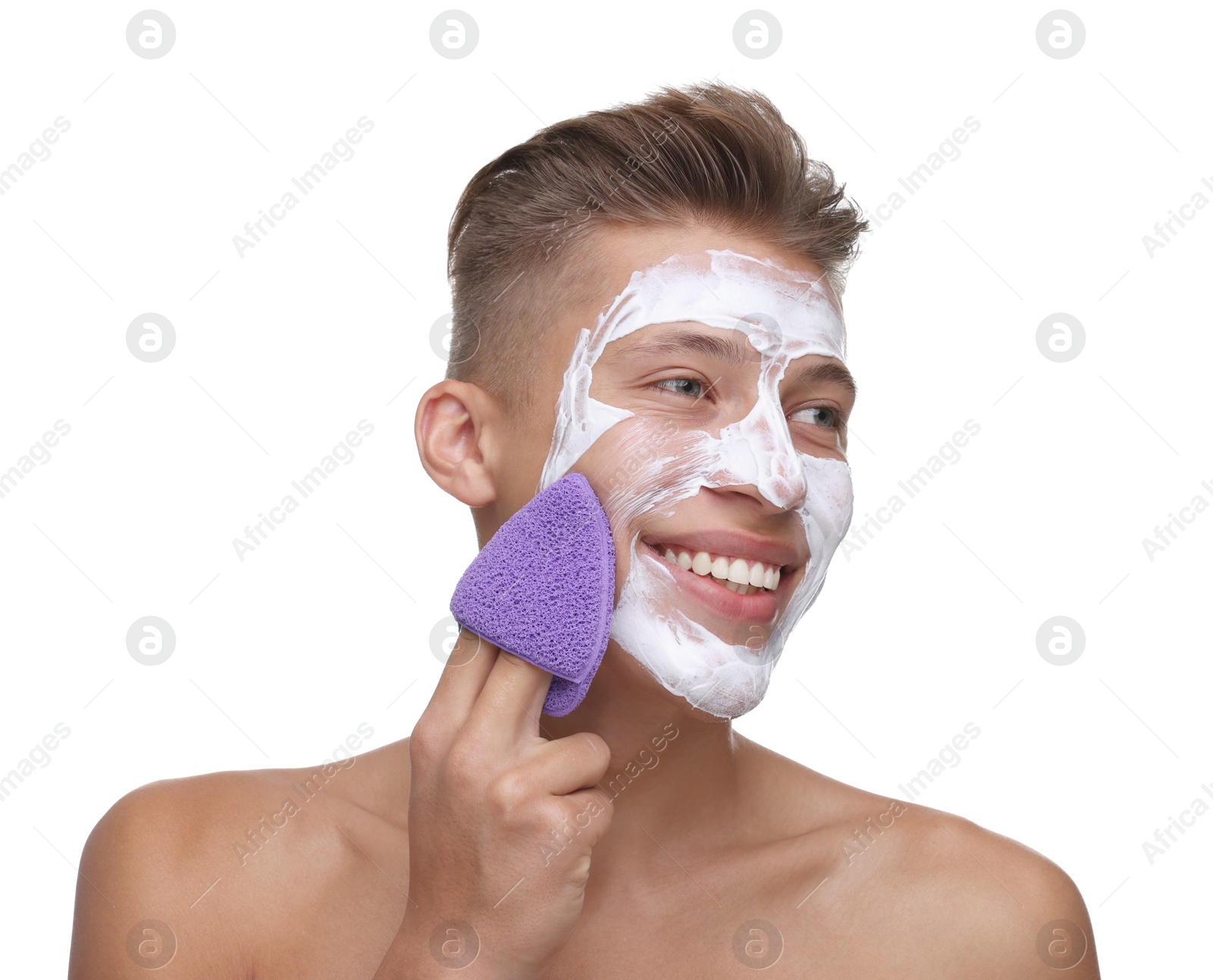 Photo of Happy young man washing off face mask with sponge on white background