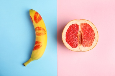 Flat lay composition with fresh banana and grapefruit on color background. Sex concept