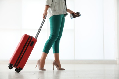 Photo of Businesswoman with red travel suitcase in airport. Space for text